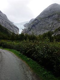 Road by mountains against sky