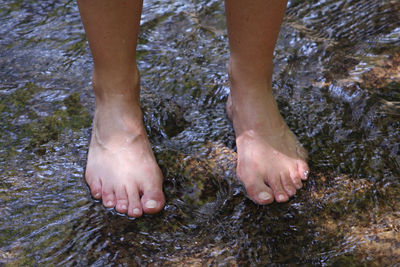 Low section of man standing in water