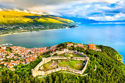 High angle view of sea and cityscape against sky