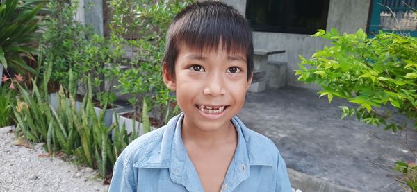 Portrait of smiling boy standing against plants