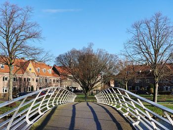 Trees and houses against sky in city