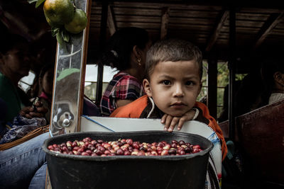 Portrait of boy with fruits at market stall