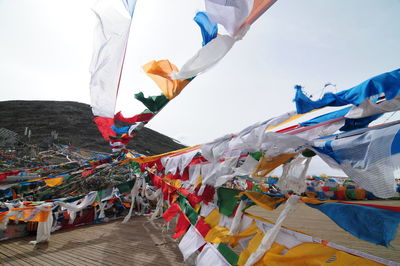 Multi colored flags hanging outside temple against sky