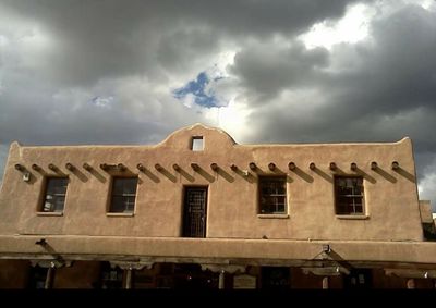 Low angle view of building against cloudy sky