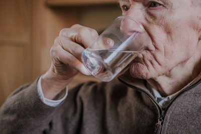 Close-up of senior man drinking water