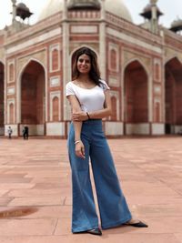 Portrait of woman standing against historic building