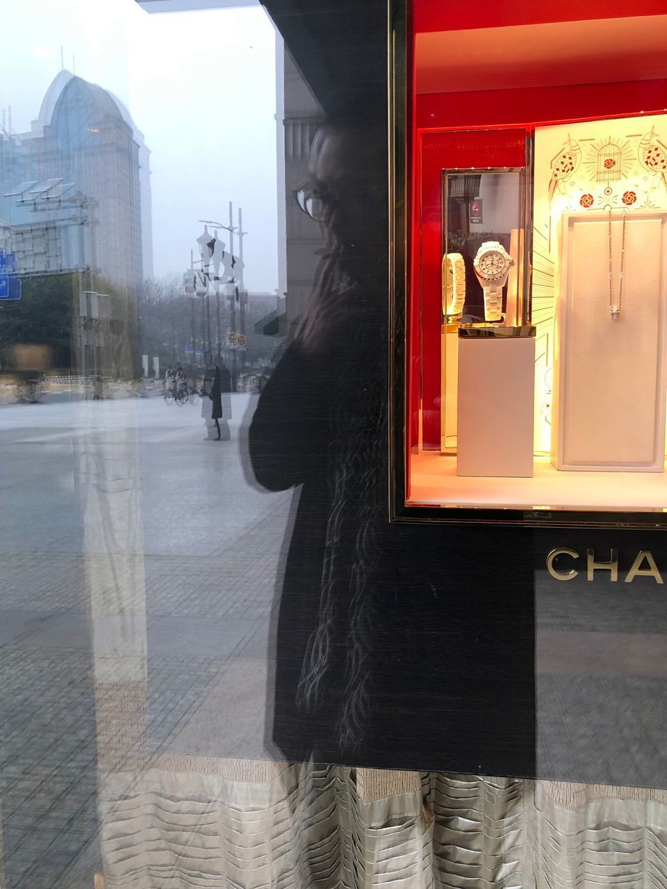 REFLECTION OF WOMAN IN GLASS WINDOW