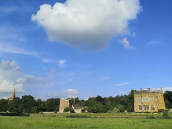 Old building on field against cloudy sky