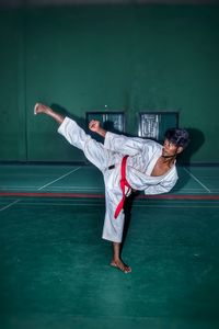 Full length of young woman exercising on floor