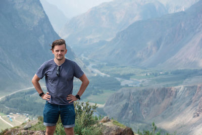 Portrait of young man standing on mountains