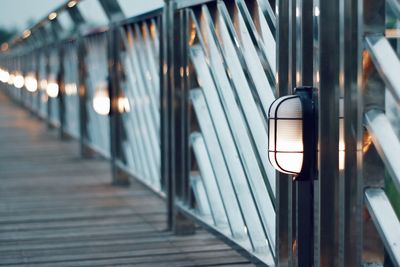 Illuminated lights on railing of footpath