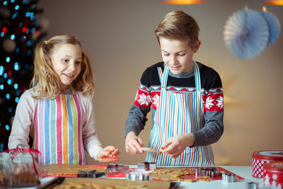 Siblings preparing cookies at home