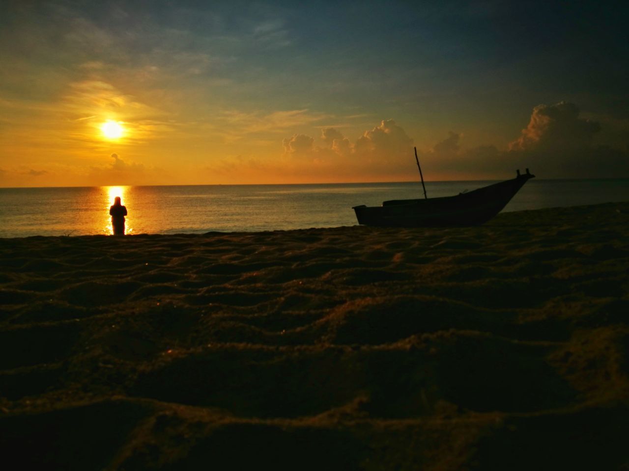 SILHOUETTE PERSON IN SEA AGAINST SUNSET SKY