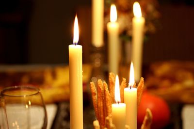 Close-up of burning candles on table