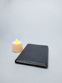 High angle view of candle on table against white background