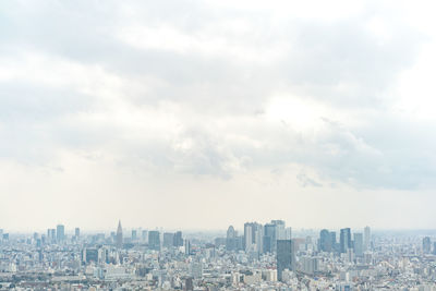 Aerial view of buildings in city against sky