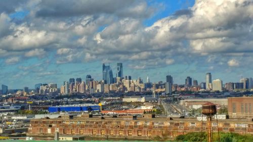 View of cityscape against cloudy sky