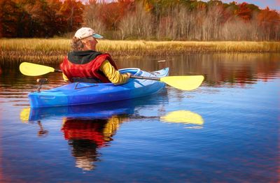 Rear view of person kayaking on river