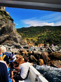 Group of people on rock against sky