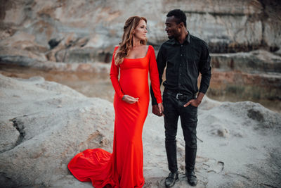 Young couple standing on red rock