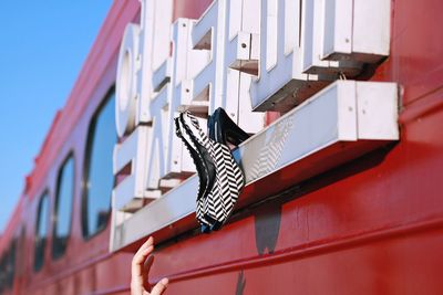 Cropped hand of woman reaching towards high heels stuck on train