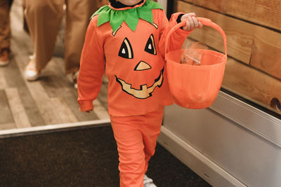 The kids collecting candy on pumpking baskets at halloween trick or treat event