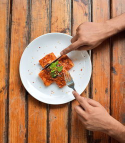 Directly above shot of woman holding food on table