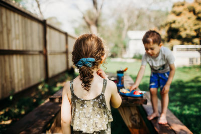 Two preschool age kids eating lunch outside at home