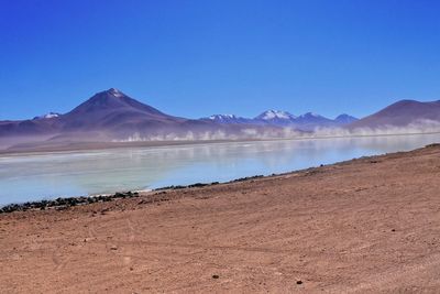 Scenic view of mountains against clear blue sky