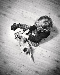 High angle view of girl lying on hardwood floor at home