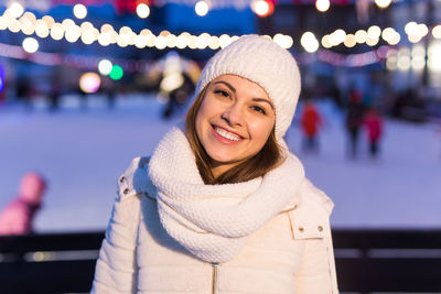 Portrait of smiling young woman standing in city