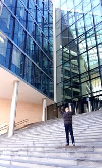 Rear view of man walking on staircase in building