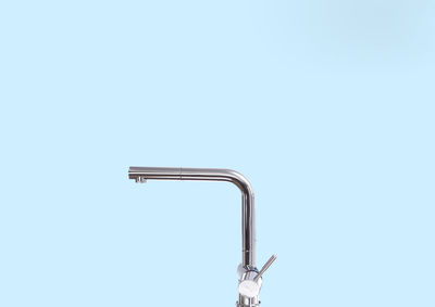 Close-up of faucet over blue background