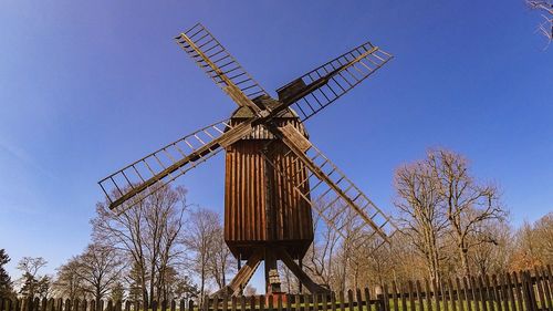 Low angle view of traditional windmill against clear blue sky