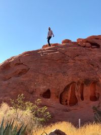 Man standing on rock against clear sky