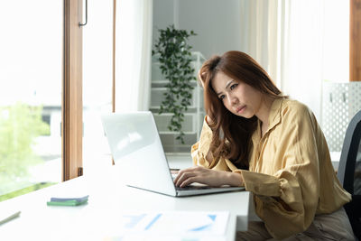 Young woman using laptop at home
