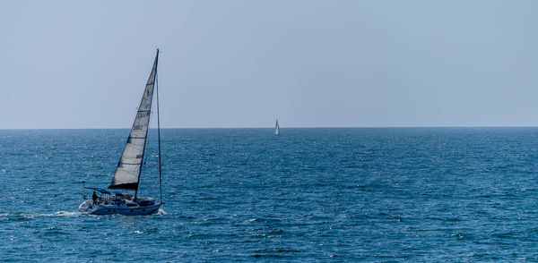 Sailboat sailing in sea against sky