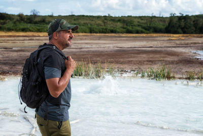 Hiker visits the caldera, a small circular crater with a marsh of sulphurous waters from the volcano