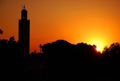 Silhouette of clock tower against sky during sunset