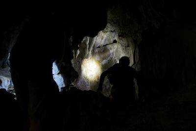 Rear view of silhouette people in cave