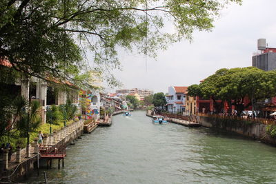 Canal amidst buildings in city against sky