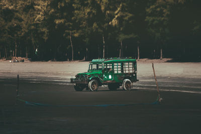 Jeep on beach by trees in city