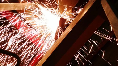 Low angle view of illuminated fireworks against sky at night