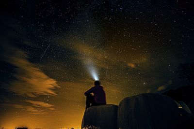 Low angle view of man against sky at night