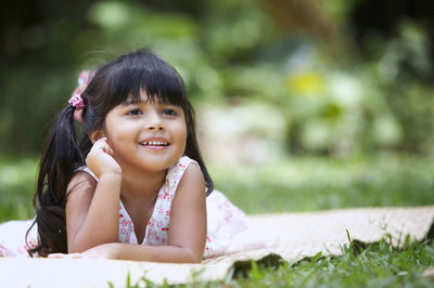 Portrait of smiling girl lying on field