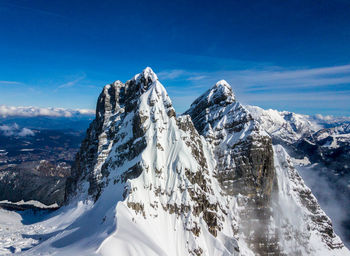 Panoramic view of snowcapped mountains against blue sky