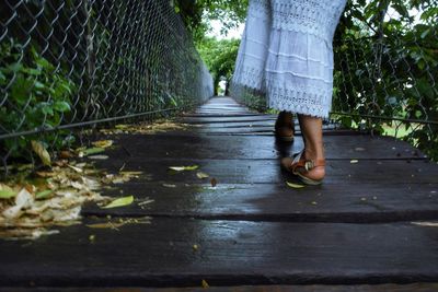 Low section of woman standing on footpath