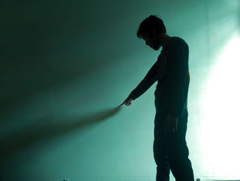 Side view of silhouette man standing against illuminated stage