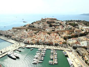 High angle view of townscape by sea against sky