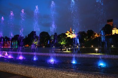 Panoramic view of fountain in city against sky at night